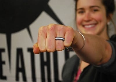 Model Shannon smiling brightly with her fist extended towards the camera, showing off her Zealology Ring.